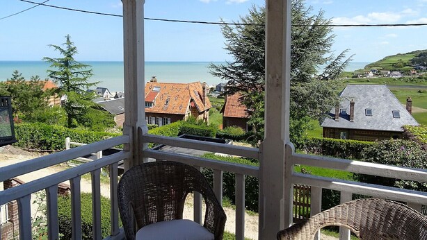 A balcony with wicker chairs, overlooking a coastal view with houses and greenery. - Consolata (Hautot-sur-Mer)