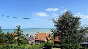 A coastal residential area with houses, a clear sky, and a view of the sea. - Consolata (Hautot-sur-Mer)