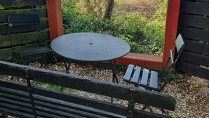 Un conjunto de banco y mesa de madera frente a un paisaje natural con vista al mar.