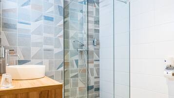 Une salle de bain moderne avec une douche à parois de verre, un meuble-lavabo en bois et des toilettes.