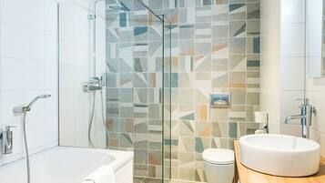Une salle de bain moderne avec une douche à parois de verre, une baignoire blanche et un meuble-lavabo en bois.