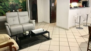 Una sala de estar con un sofá, una mesa de centro y un cuadro en la pared.
