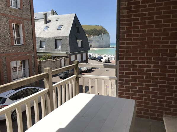 Een balkon met uitzicht op de kust, inclusief een klif en een strand.
