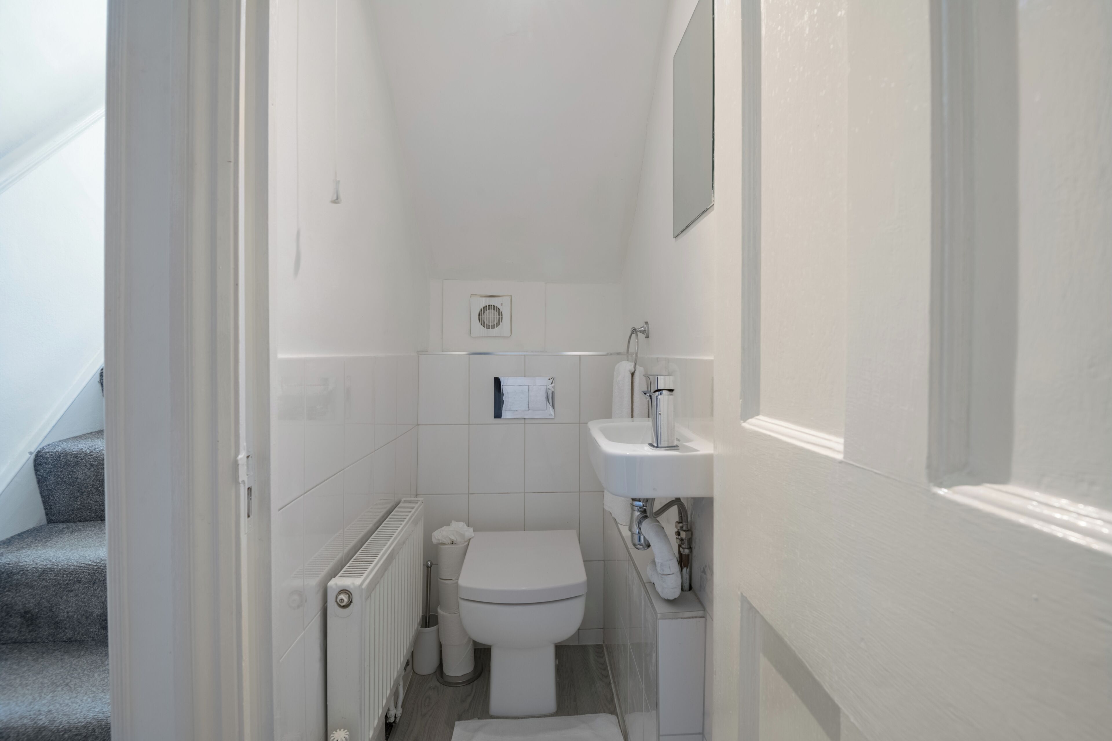 Un bagno piccolo e funzionale con il water, termosifone e lavandino.