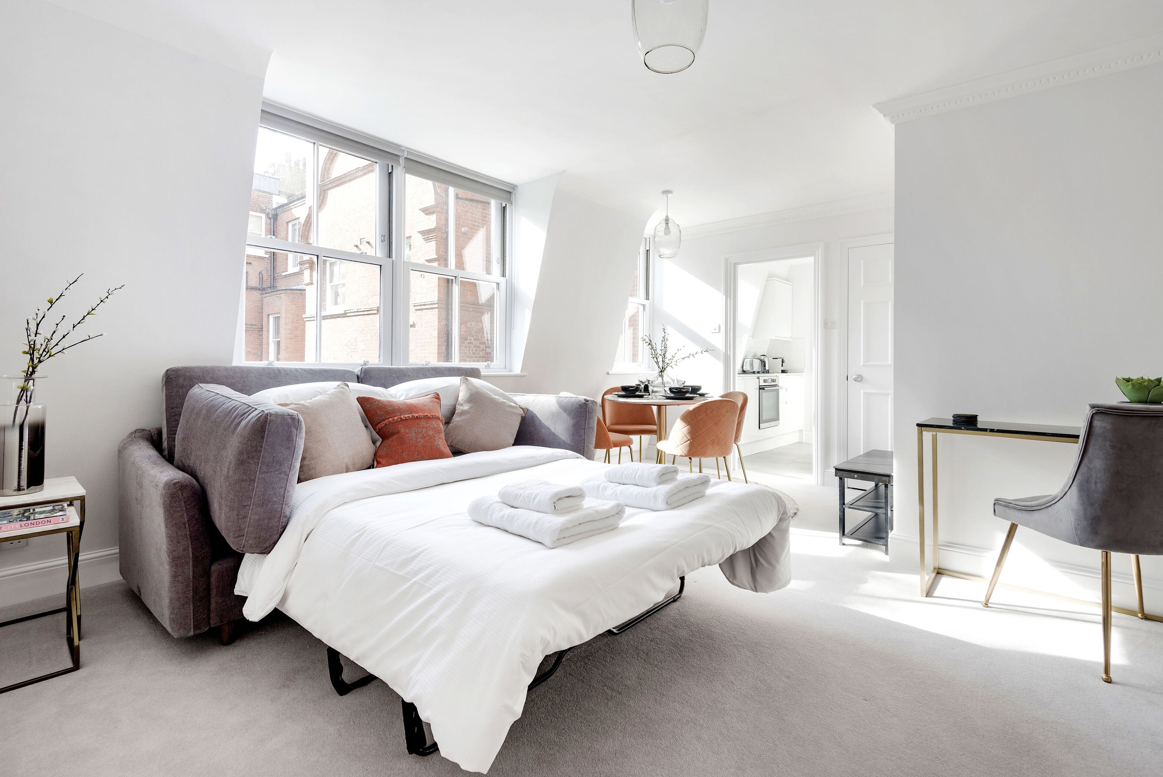 A modern bedroom with a large bed, a desk, and a chair.