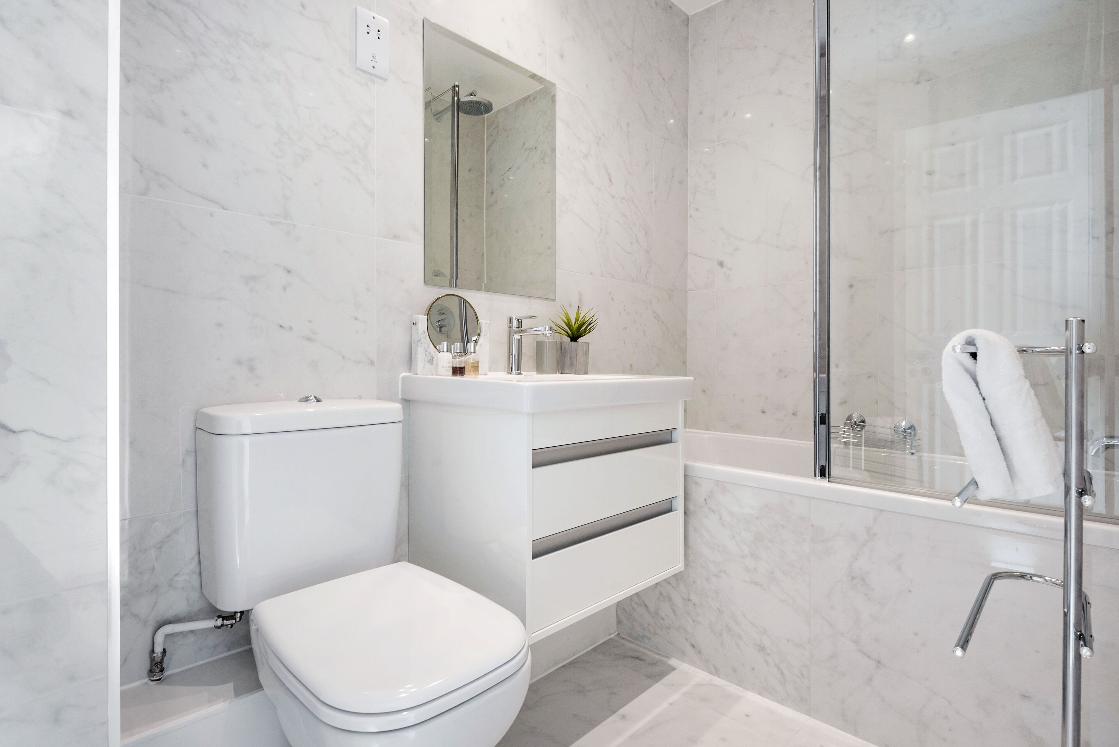 A modern bathroom with a toilet, sink, and shower.