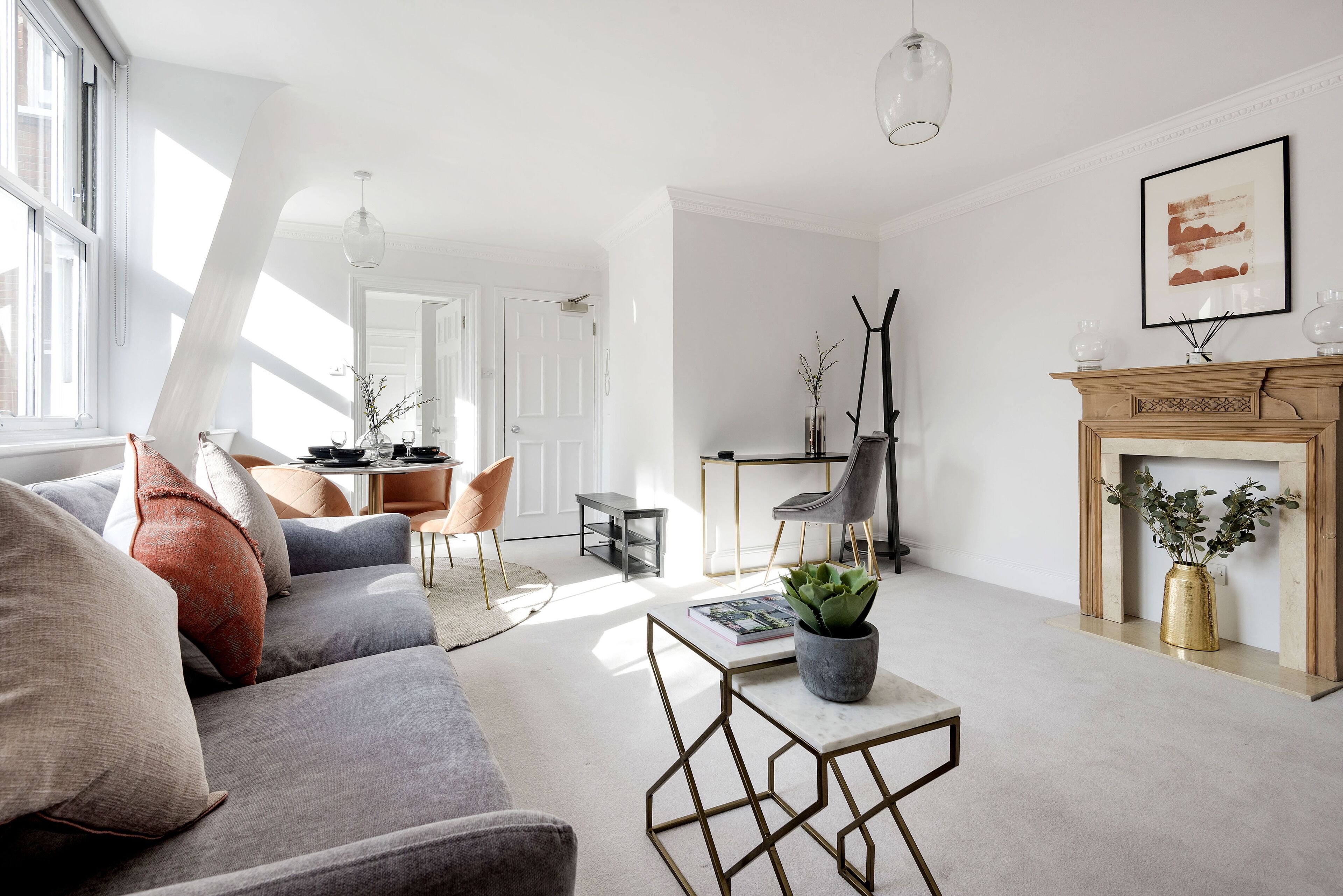 A modern living room with a grey sofa, a coffee table, and a fireplace.