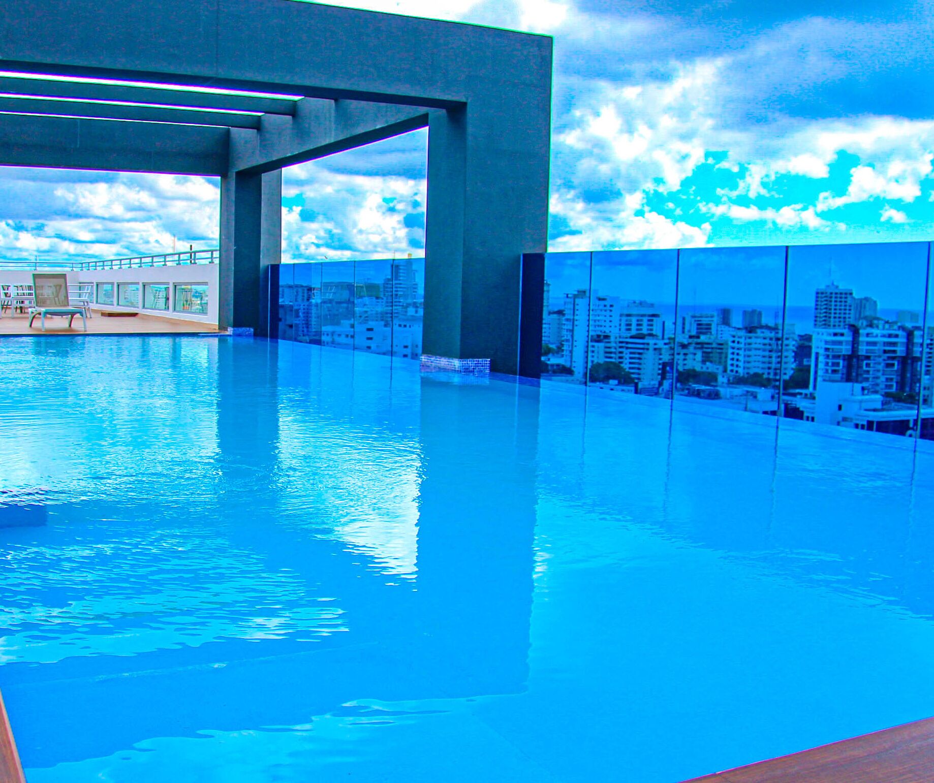 Una piscina interior con un mural de un paisaje urbano en las paredes, cielo despejado y vistas de la ciudad a través de la piscina.