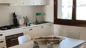 A modern kitchen with white cabinets, a gas stove, and a window above the sink.