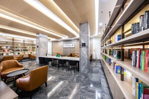 A modern library interior with marble floors, leather seating, and bookshelves. - Atour Hotel Hengyang West Jiefang Road (Hengyang)