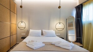 Una habitación de hotel con una cama grande, dos mesitas de noche, un espejo y un armario.