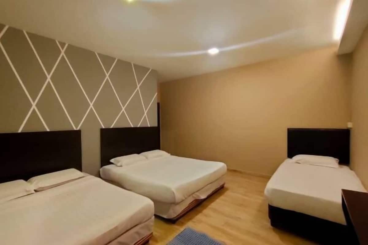 A hotel room with three beds, a wooden floor, and a geometric wall design.
