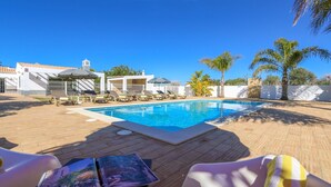 A swimming pool with lounge chairs and umbrellas, surrounded by palm trees and a white building with a tiled roof. - ★Stunning Luxury Villa w/Private Pool, n/Galé Beach, Albufeira (Albufeira)