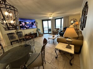 Relax in a spacious living room with a large flat-screen TV, dining area, and comfortable seating options.