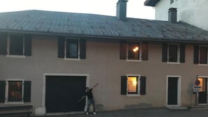 Een gebouw met een garagepoort, een persoon ervoor en een verkeersbord.