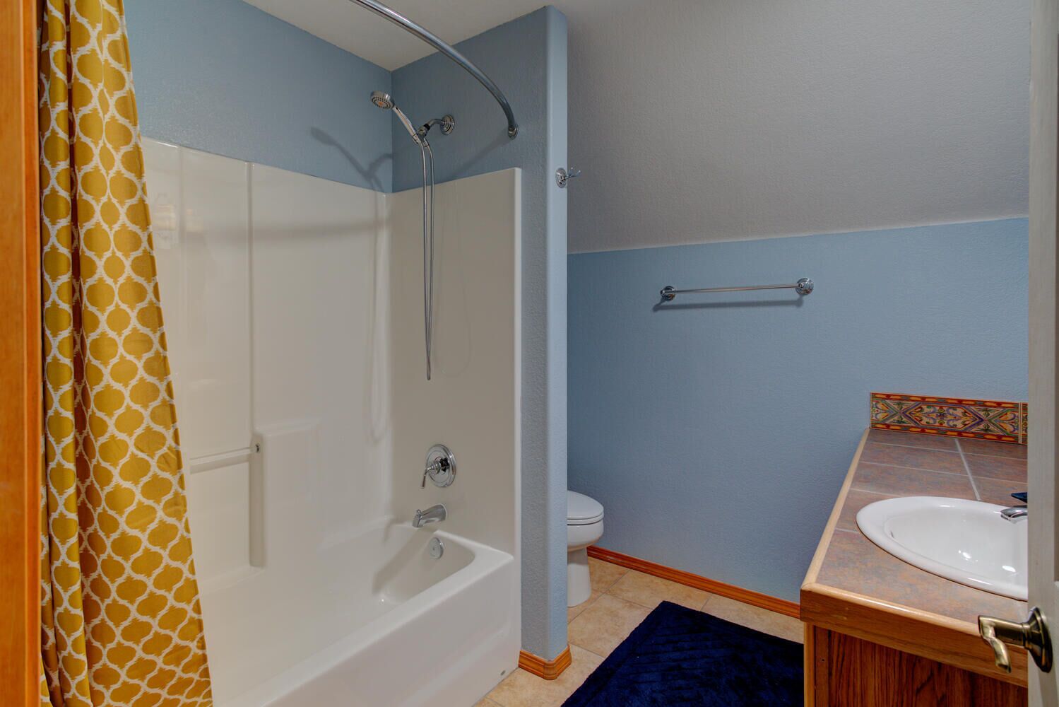 A bathroom with a shower, toilet, and sink.