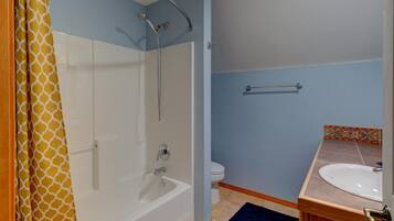 A bathroom with a shower, toilet, and sink.