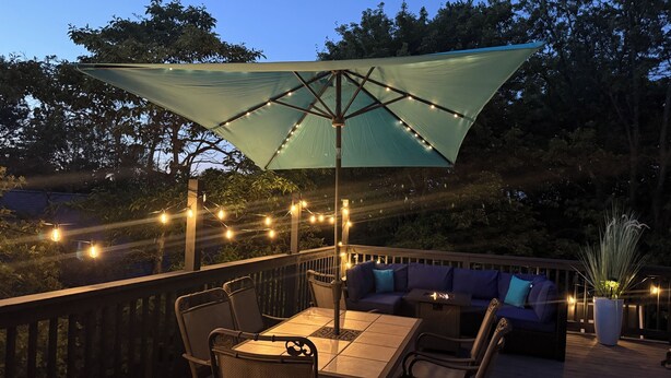 An outdoor deck with a table and chairs, a cushioned seating area, and string lights. - Luxury Vacation home in the Poconos close to the lake and community pool.  (Albrightsville)