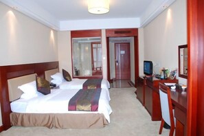 A hotel room with a large bed, a desk, a television, and a mirror. - Runying Hotel (Tianchang)