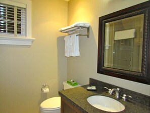 A bathroom with a white sink, a mirror, a toilet, and a towel rack.