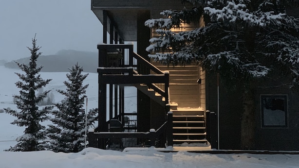 Un bâtiment recouvert de neige, avec un escalier menant à un deuxième étage.