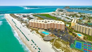 A coastal hotel with multiple buildings, a beach, and a marina.