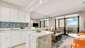 A modern kitchen with white cabinetry, a tiled backsplash, and a central island.