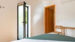 A bedroom with a bed, a door, and a window. - Douroparadise (Caldas de Moledo)