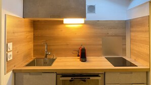 Una cocina compacta con tragaluz, pileta de acero inoxidable y lavavajillas integrado.