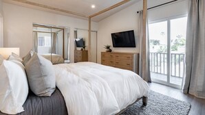 A bedroom with a large bed, a TV, a dresser, and a balcony with curtains. - The Rosemont II - 2BR La Jolla Gem Near the Beach (San Diego)