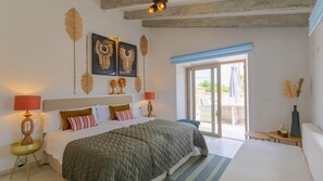 A bedroom with a bed, two bedside tables with lamps, a large window, and decorative wall art. - CA NA ROSSA (SINEU) - Beautiful house with private pool in the center of Mallorca - Free W (Sineu)