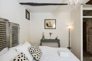 Cozy retreat with a neatly made bed, nightstand, and modern lamp.