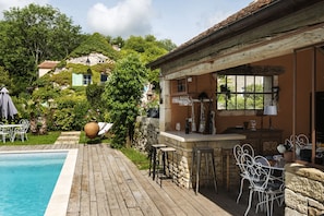 Een buitenzwembad, een verwarmd zwembad en ligstoelen