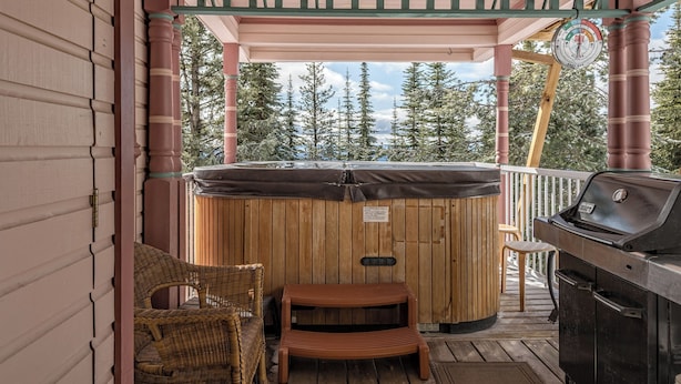 A wooden hot tub on a deck with a grill and wicker chairs. - Large suite on the Knoll in a cul-de-sac w/ a private hot tub and pet friendly! (Silver Star Mountain)