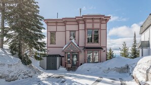 A two-story pink house with a front porch, a chimney, and a garage. - Large suite on the Knoll in a cul-de-sac w/ a private hot tub and pet friendly! (Silver Star Mountain)