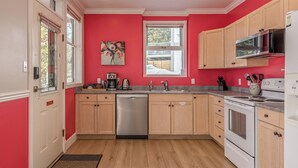 A kitchen with wooden cabinets, a stainless steel dishwasher, a microwave, and a stove. - Large suite on the Knoll in a cul-de-sac w/ a private hot tub and pet friendly! (Silver Star Mountain)