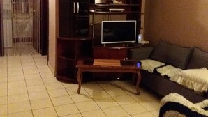 A living room with a television on a wooden stand, a ceiling fan, and a sofa. - Coco beach Guanacaste Costa Rica Natural Fun!!!!! (Coco)