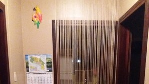 A narrow hallway with a calendar on the wall, a radiator, and a door with a curtain. - Coco beach Guanacaste Costa Rica Natural Fun!!!!! (Coco)