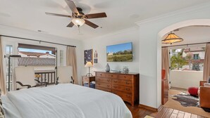 A bedroom with a bed, a ceiling fan, a dresser, a TV, and a view of the outside. - Superb La Vida Riviera 2 BD 2BA Gorgeous Riviera Views, Walk Everywhere! (Santa Barbara)