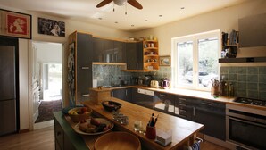 Una cocina moderna con una isla central, armarios de madera y un ventanal que proporciona luz natural.