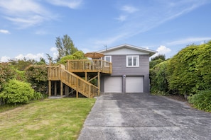 A two-story house with a wooden deck and a garage.