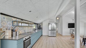 Eine moderne Küche mit blauer Arbeitsplatte, Edelstahlgeräten und einer gefliesten Spritzschutzwand.