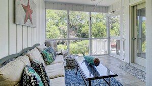 A sunlit room with a sofa, coffee table, and a starfish decoration. - Award-Winning Resort Amenities | Racquet Club 2 (Isle of Palms)