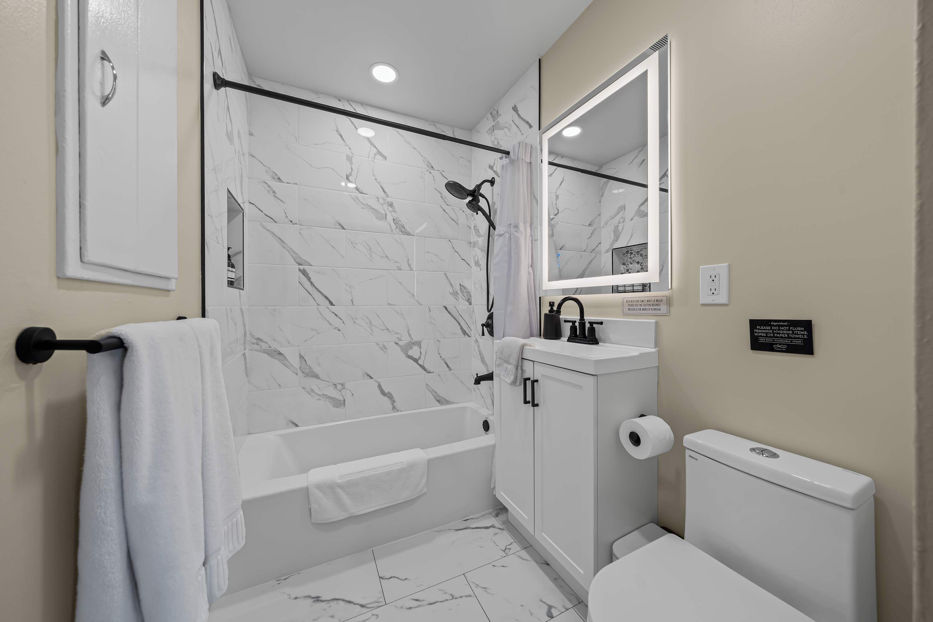 A modern bathroom with a bathtub, toilet, and sink.