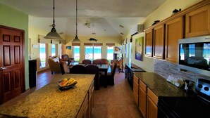 A spacious kitchen with a large island, wooden cabinets, and a built-in microwave.