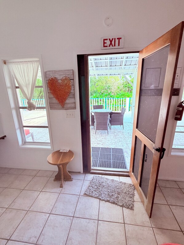A room with a tiled floor, a small round table, a heart-shaped decoration, and an exit sign.