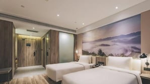 A hotel room with a large bed, two bedside tables, a nightstand, and a wall-mounted lamp. - Atour Hotel (Chongqing)