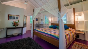 Een slaapkamer met een bed, nachtkastje, bureau en stoel.