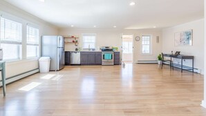 A spacious kitchen with modern appliances, a dining area with a table and chairs, and a large window providing natural light. - Blue Star (Salisbury)