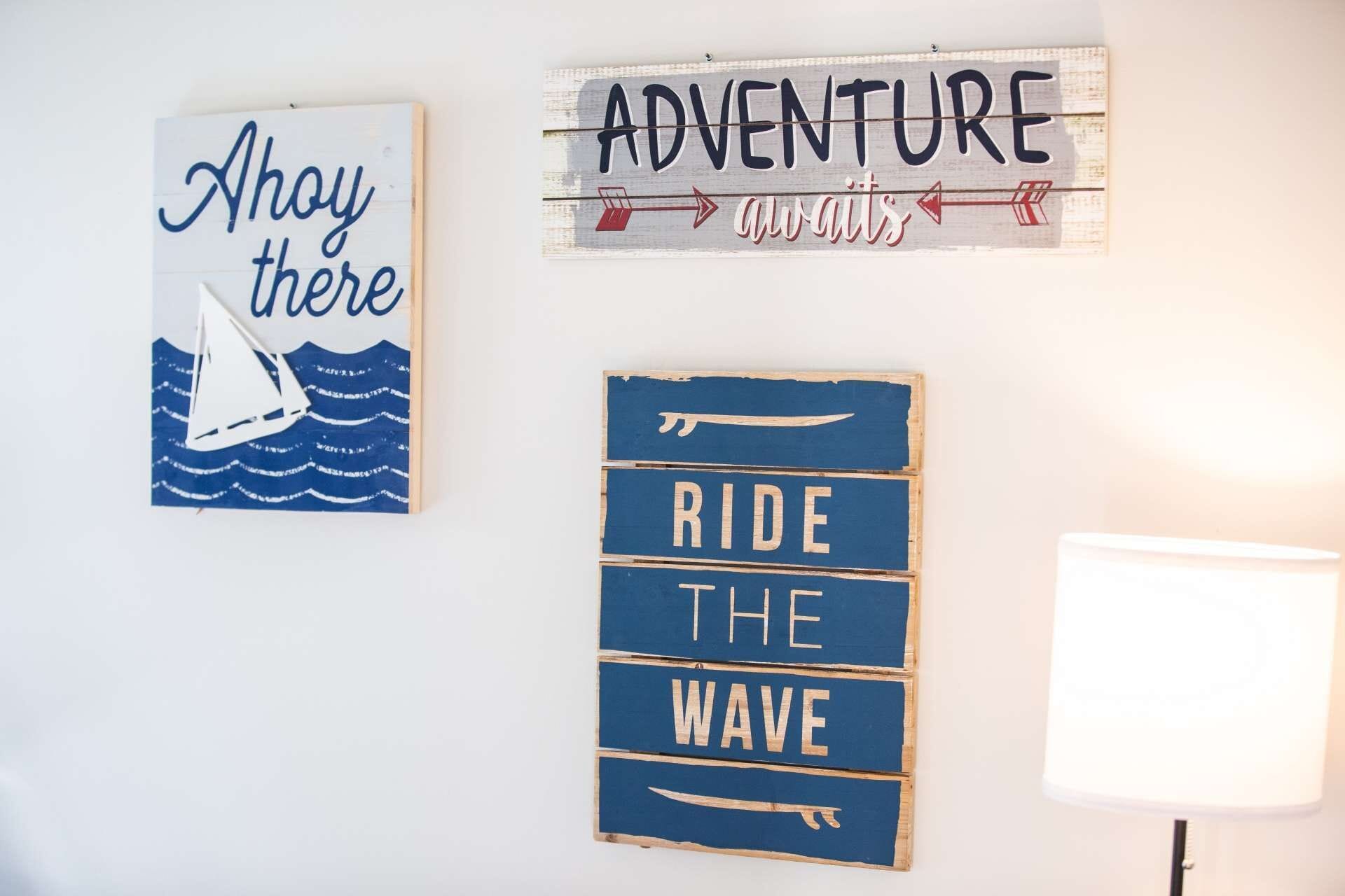 Three wall decorations: 'Ahoy there', 'Adventure awaits', and 'Ride the wave'.
